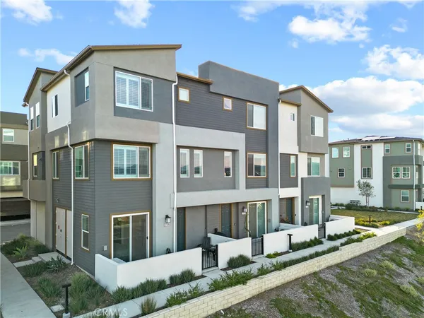 a front view of a building with a garden and plants