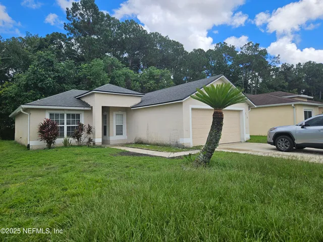 a view of a house with a yard and sitting area