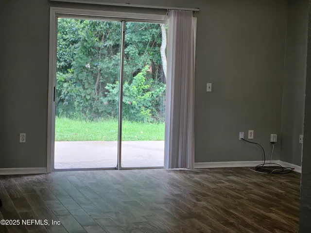 a view of empty room with yard view and floor to ceiling window