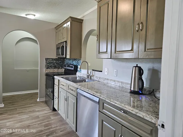 a kitchen with granite countertop cabinets sink and stove