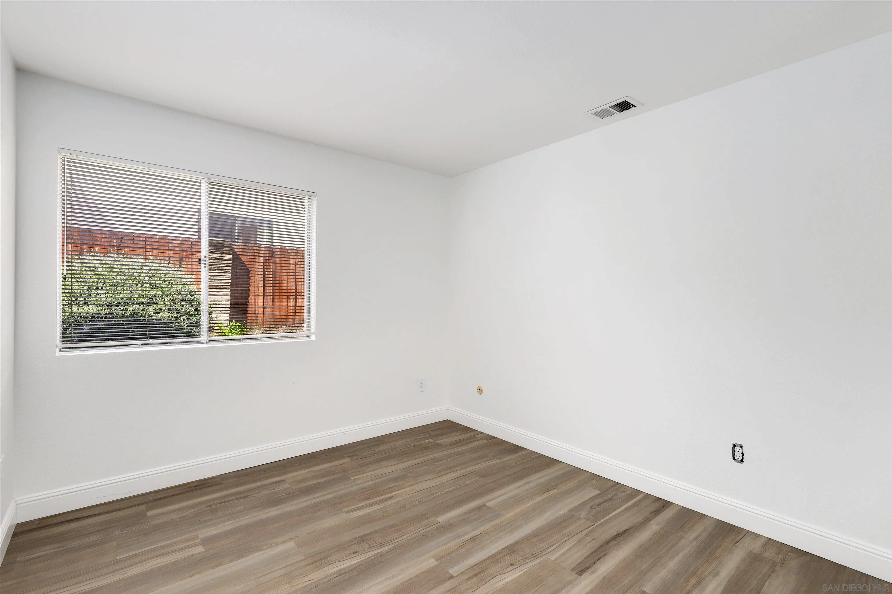 3933 Brown Street Oceanside, CA 92056 - Photo 18 of 25 an empty room with wooden floor and windows