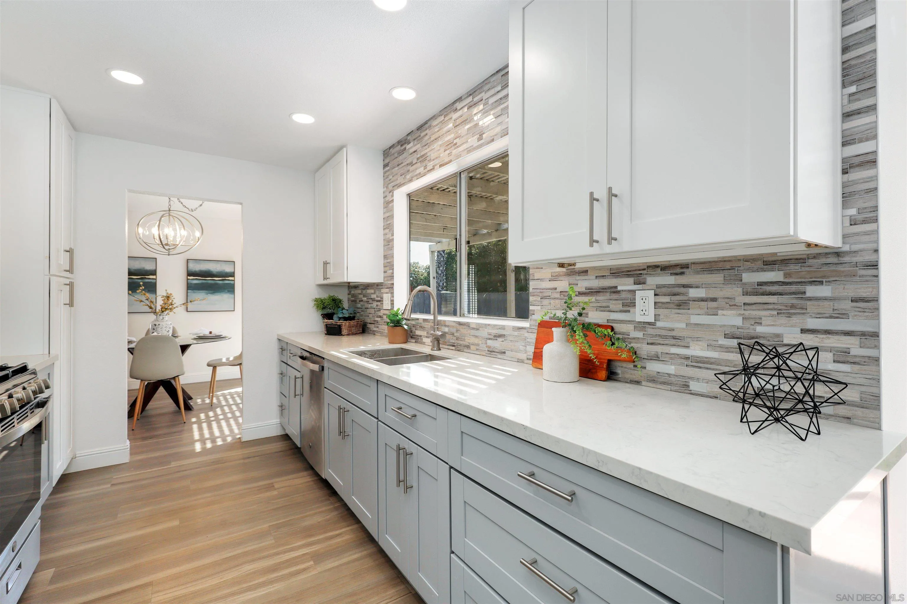 3933 Brown Street Oceanside, CA 92056 - Photo 10 of 25 a kitchen with sink a stove and white cabinets