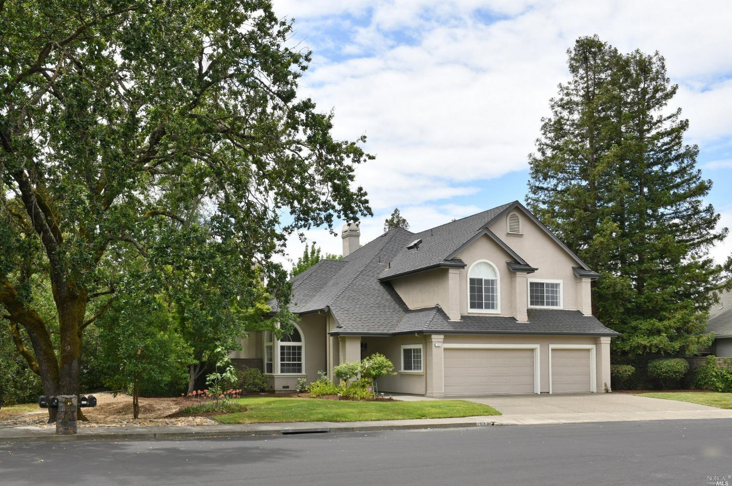 a front view of a house with a garden and yard