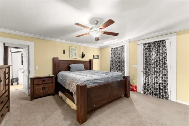 a spacious bedroom with a large bed a flat tv screen and a dresser