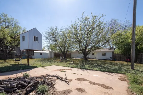 a backyard of a house with table and chairs