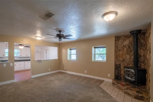 an empty room with windows cabinet and fireplace