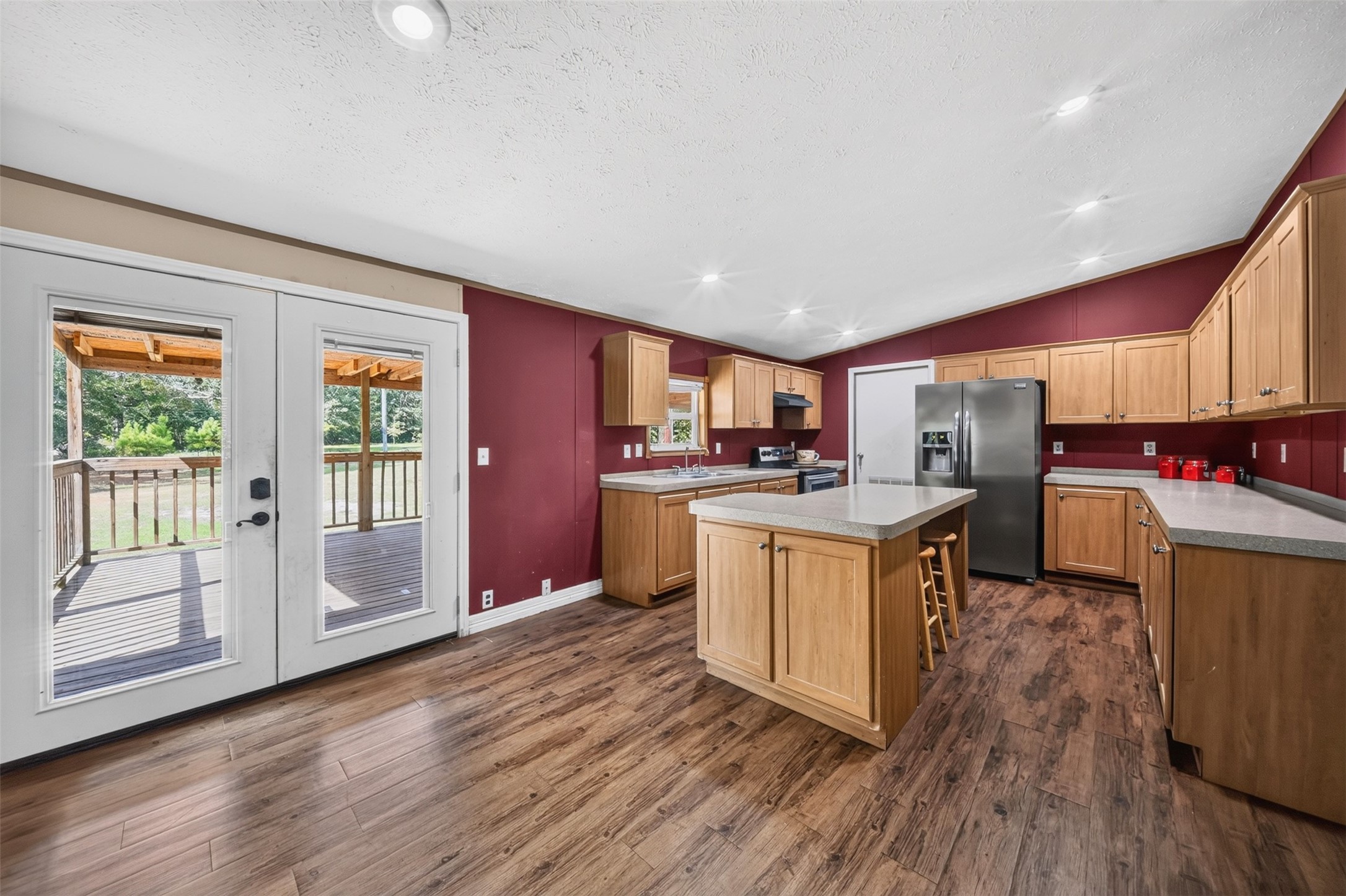 2581 Mann Road Conroe, TX 77303 - Photo 2 of 32 Spacious kitchen with center island, ample cabinetry, and views toward the backyard.