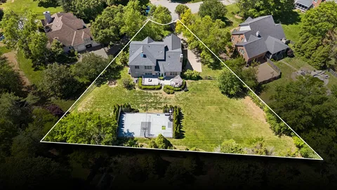 an aerial view of a house with a garden and yard