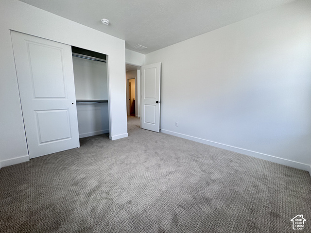 2633 Scarlet Road, Unit 259 Eagle Mountain, UT 84005 - Photo 20 of 29 Neutral tone wall paint, textured carpet flooring, white sliding closet doors, and a white interior door with black hardware