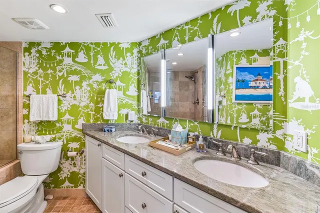 a bathroom with a granite countertop toilet sink and mirror