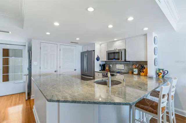 a kitchen with stainless steel appliances granite countertop a sink refrigerator and microwave