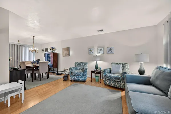 a living room with furniture and a dining table with wooden floor
