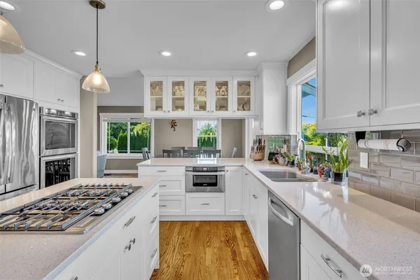 a kitchen with kitchen island granite countertop a sink cabinets and stainless steel appliances