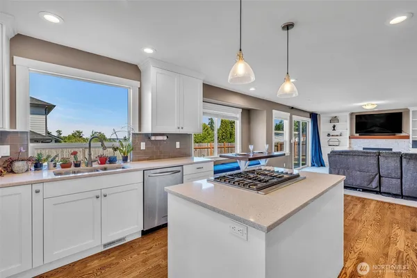 a kitchen with stainless steel appliances kitchen island granite countertop a stove a sink and a microwave