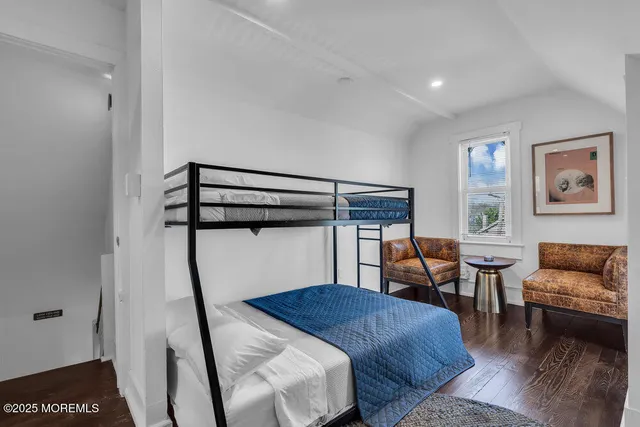 a view of a workspace with wooden floor and windows