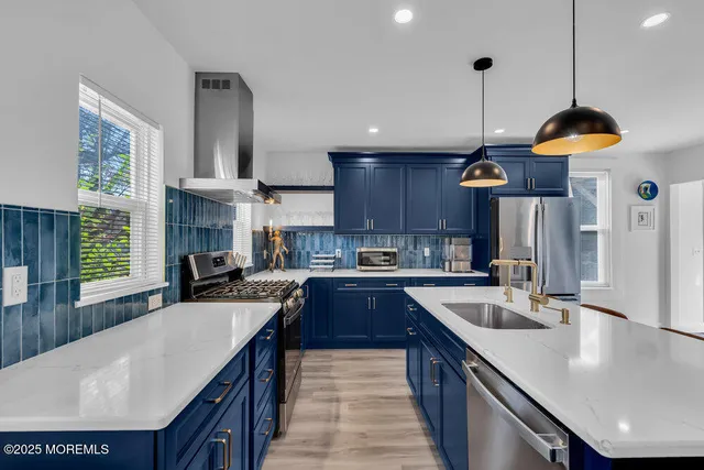 a kitchen with stainless steel appliances granite countertop a sink a stove and a wooden floors