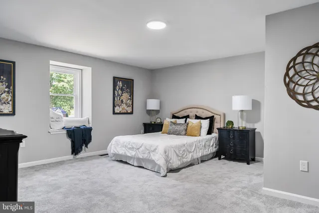 a bedroom with a bed and a lamp on dresser