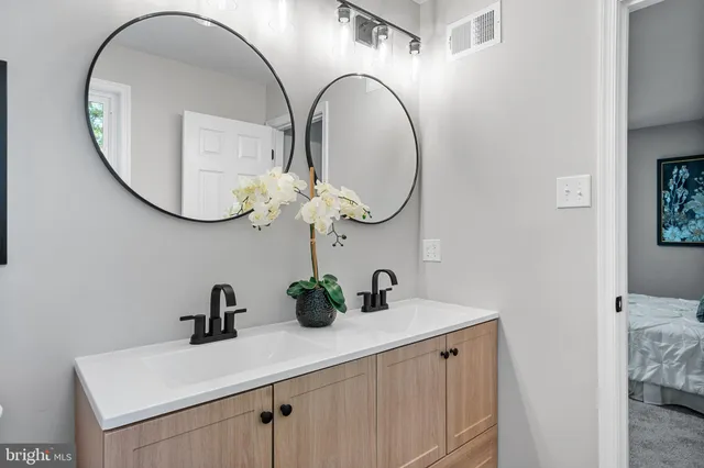 a bathroom with a toilet a sink a mirror a window and vanity