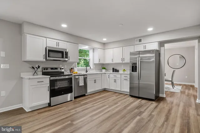 a kitchen with white cabinets and stainless steel appliances