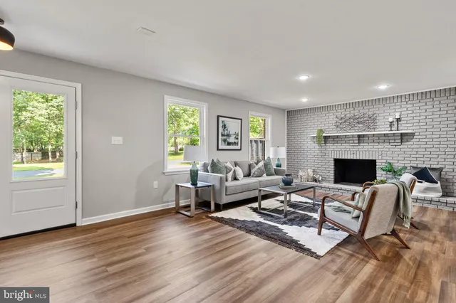 a living room with furniture a large window and a fireplace