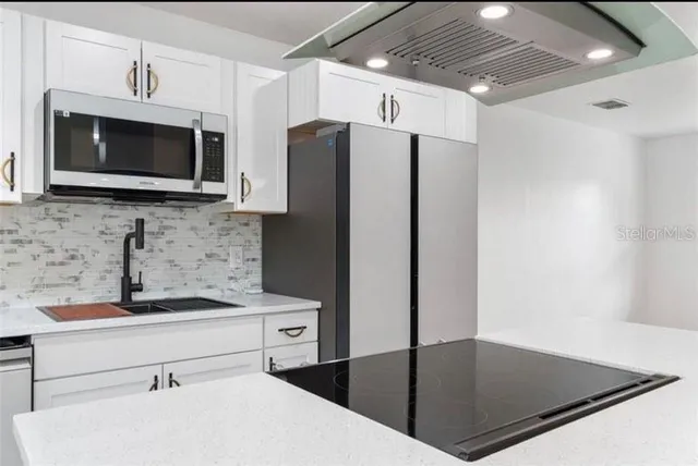 a kitchen with stainless steel appliances a microwave a sink and a refrigerator