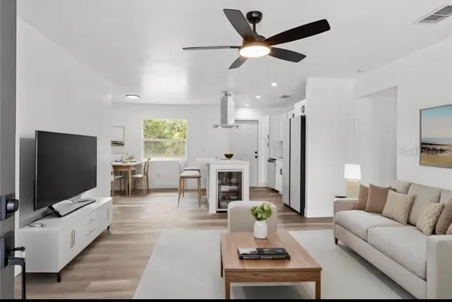 a living room with furniture a flat screen tv and a chandelier