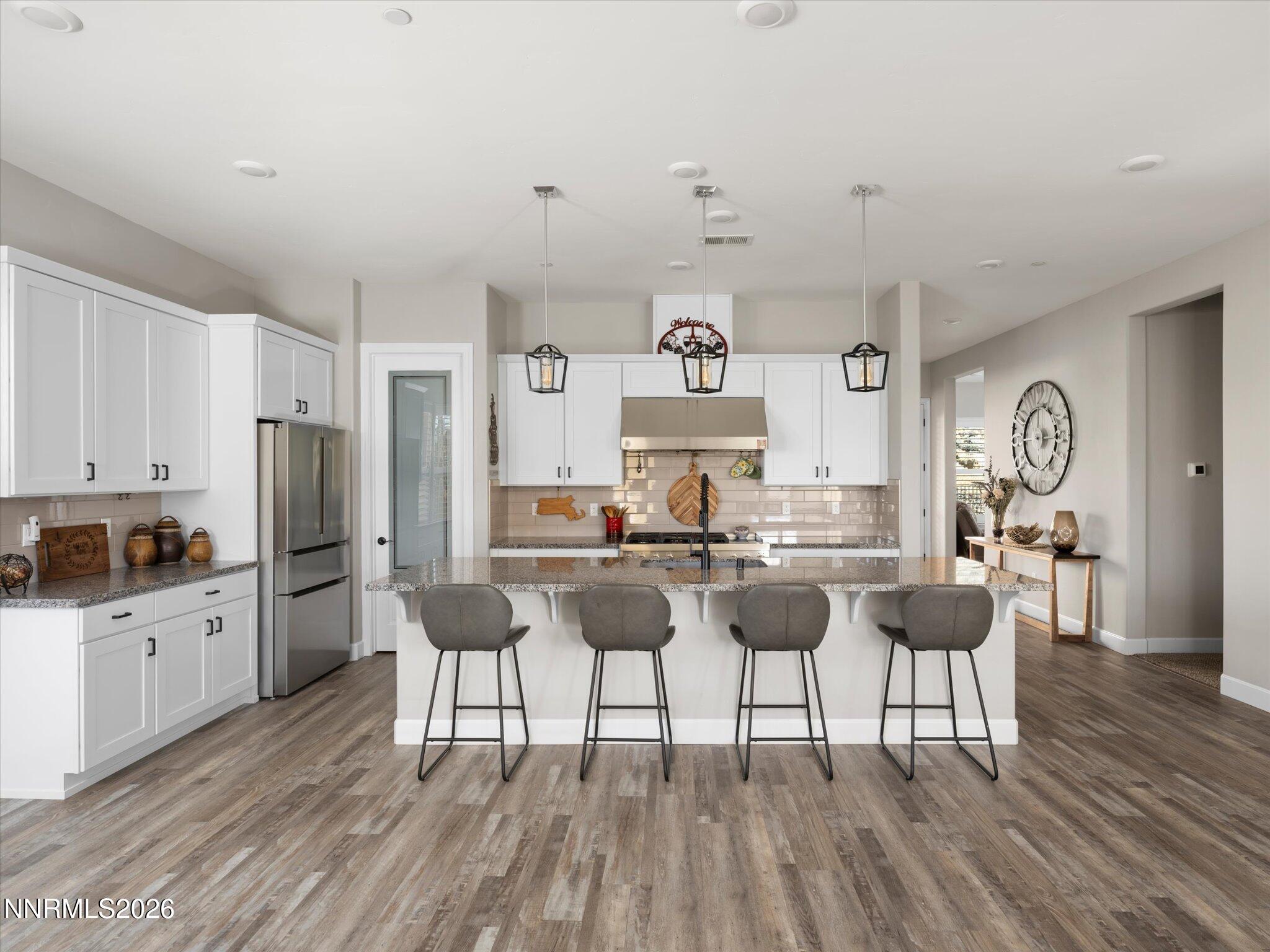 415 Gooseberry Drive Reno, NV 89523 - Photo 7 of 32 a kitchen with stainless steel appliances kitchen island granite countertop a table and chairs in it