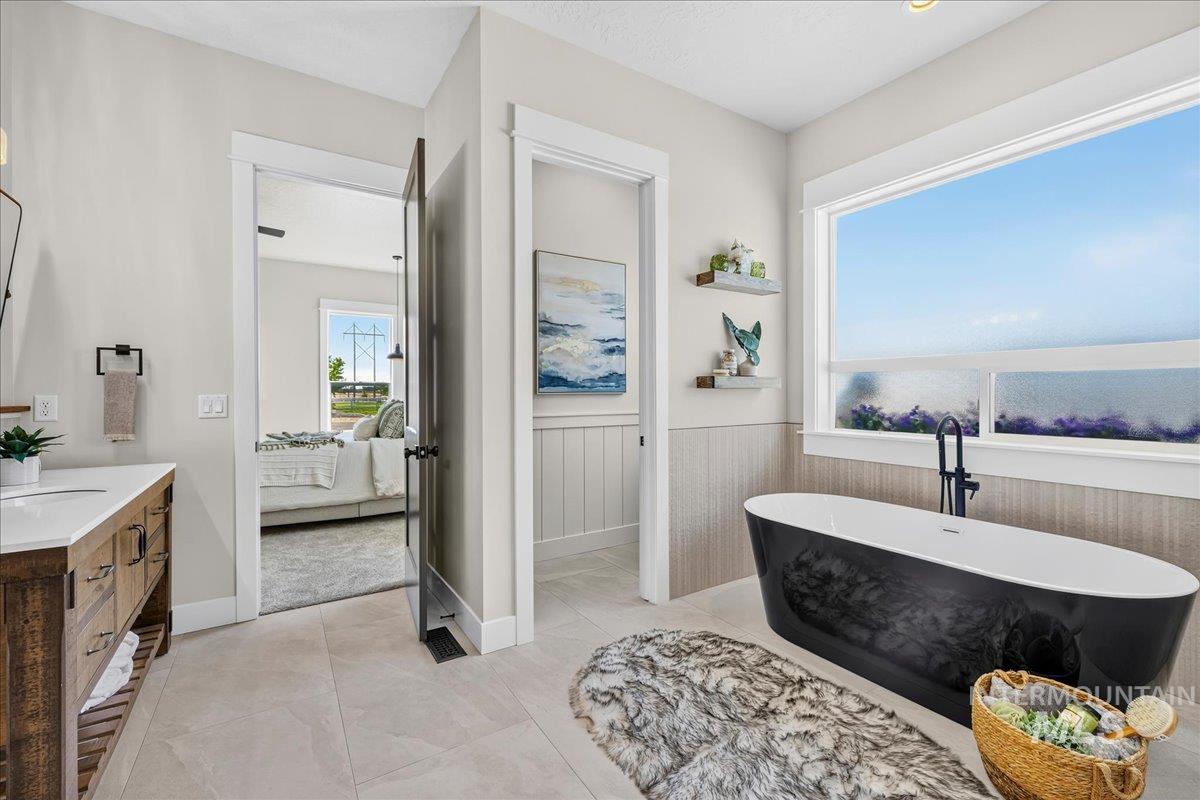 16876 Spring Meadow Drive Caldwell, ID 83607 - Photo 27 of 49 Soaking tub with matte black fixtures, framed by a large window