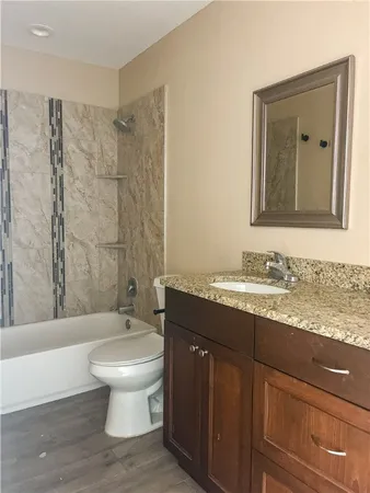 a bathroom with a granite countertop sink toilet a large mirror and shower