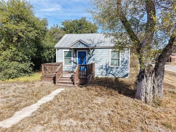 a view of a house with a yard and sitting area