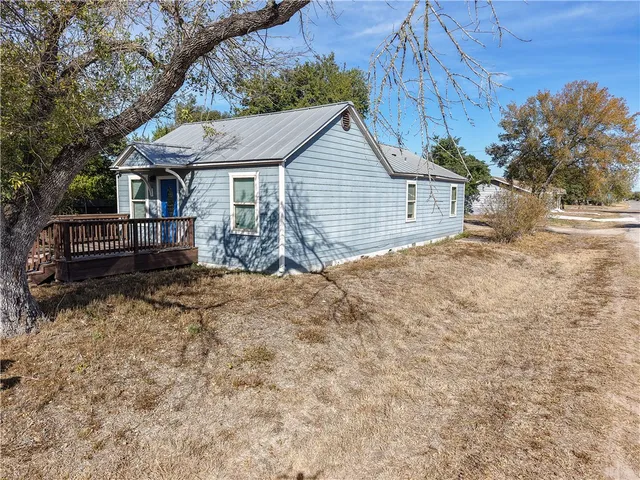 a view of a house with a yard and wooden fence