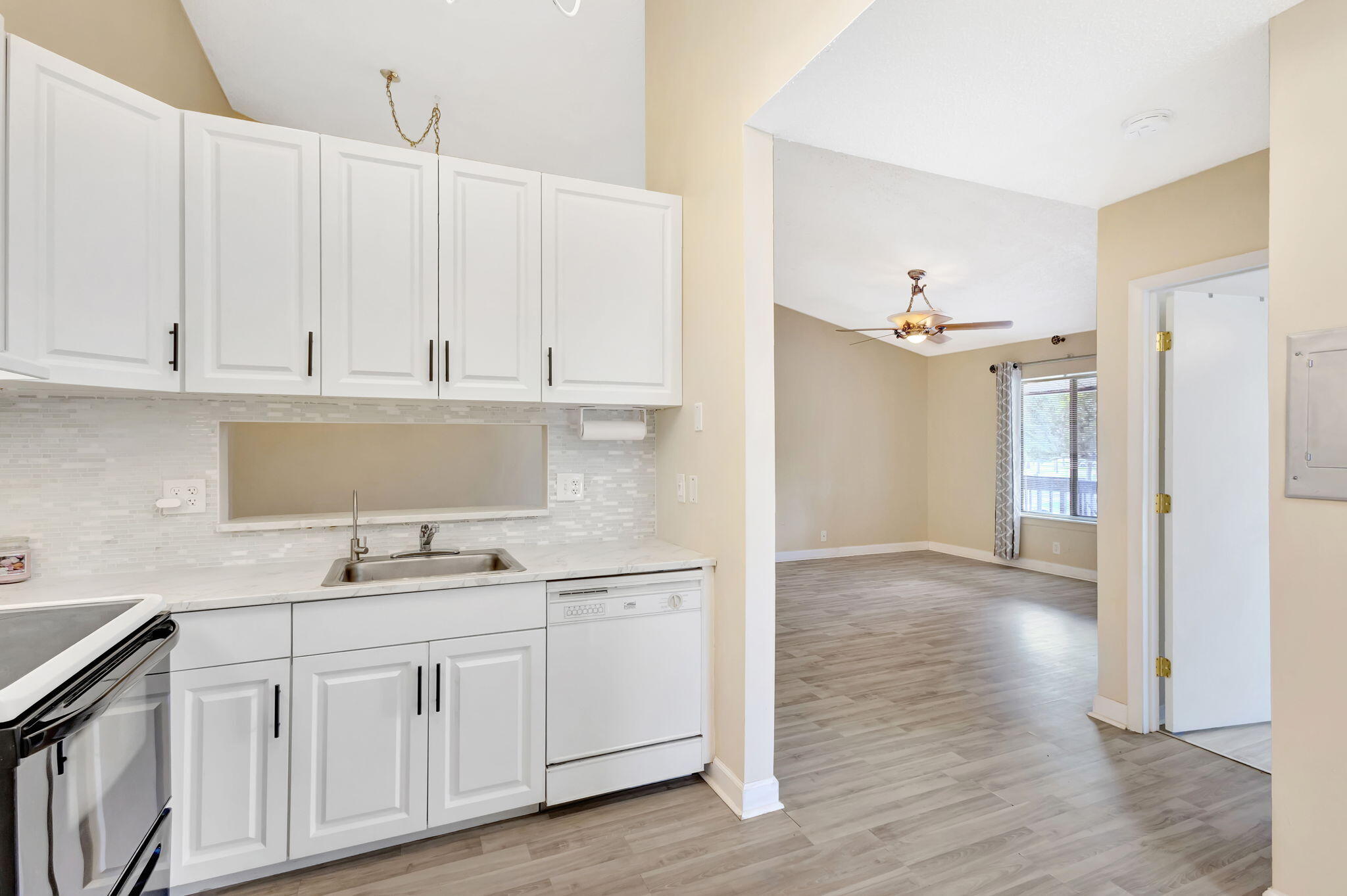 6458 Chasewood Drive, Unit E Jupiter, FL 33458 - Photo 1 of 33 a kitchen with white cabinets and sink