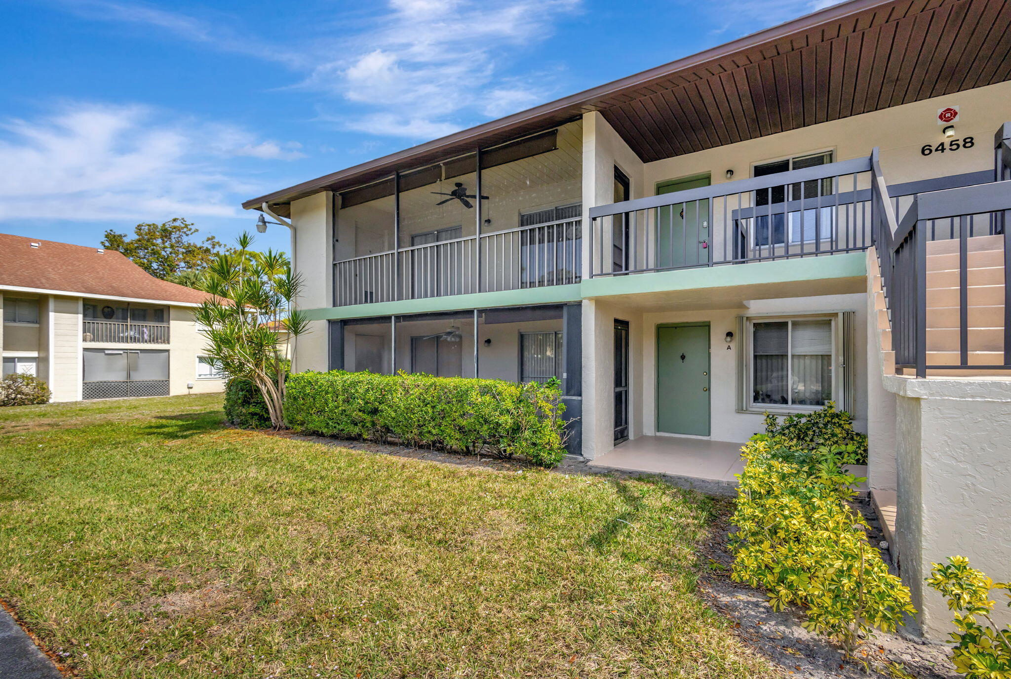 6458 Chasewood Drive, Unit E Jupiter, FL 33458 - Photo 21 of 33 front view of a house with a yard