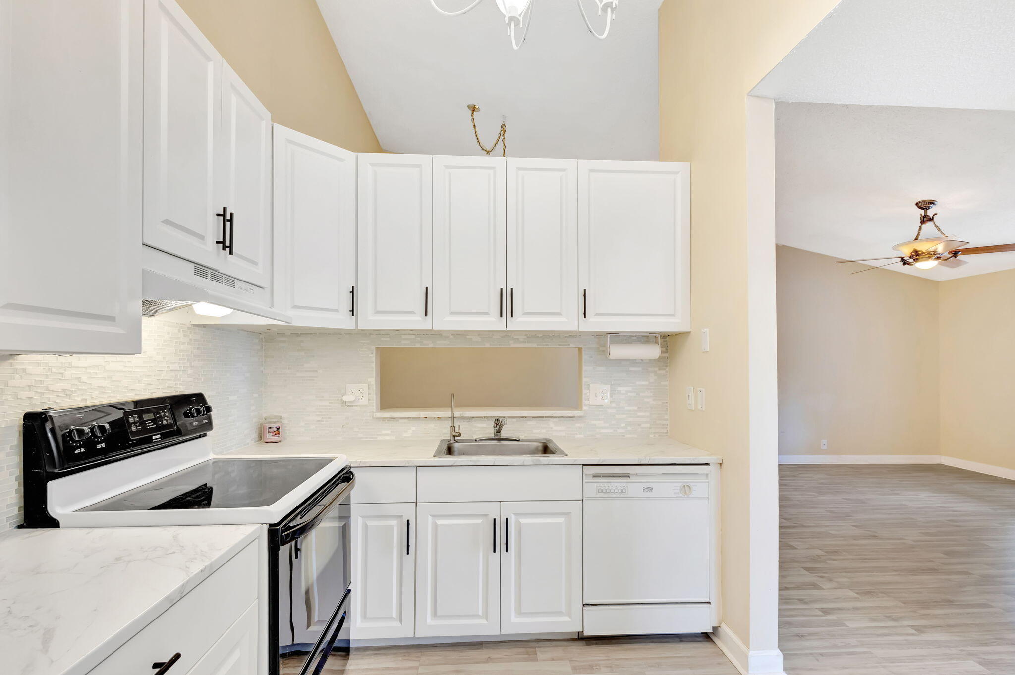 6458 Chasewood Drive, Unit E Jupiter, FL 33458 - Photo 4 of 33 a kitchen with white cabinets and appliances