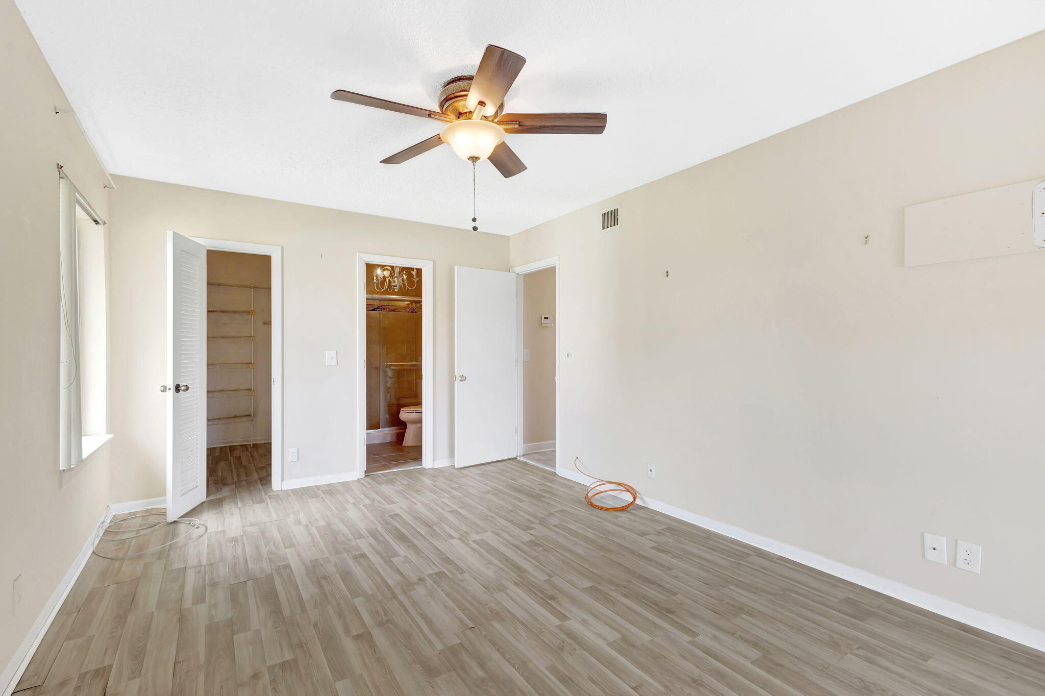 6458 Chasewood Drive, Unit E Jupiter, FL 33458 - Photo 10 of 33 wooden floor in an empty room with a window