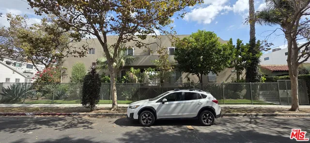a car parked in front of a white house
