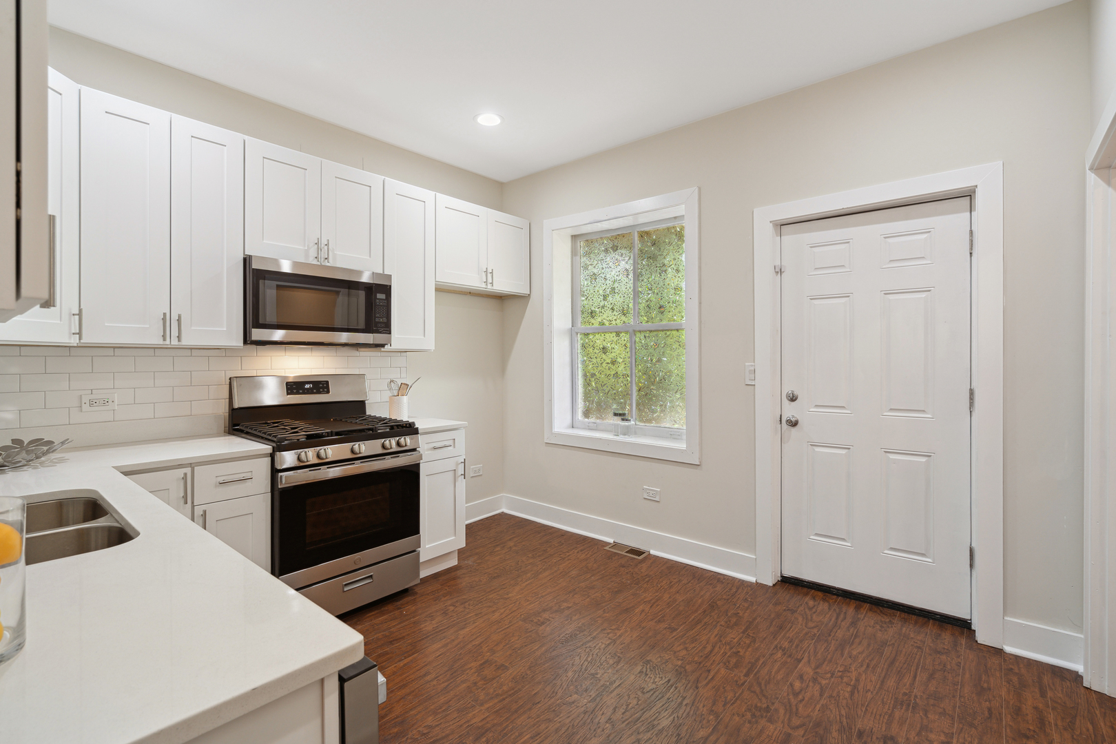 6826 South Prairie Avenue, Unit 1 Chicago, IL 60637 - Photo 7 of 20 a kitchen with granite countertop a stove a sink and a microwave