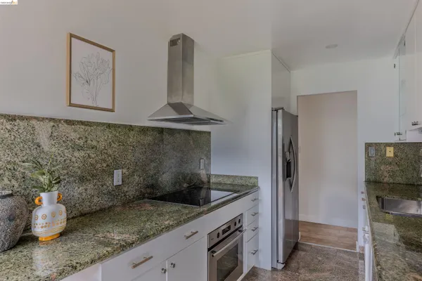 a kitchen with stainless steel appliances granite countertop a sink and a refrigerator