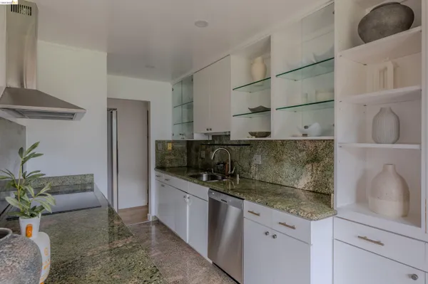 a kitchen with stainless steel appliances granite countertop a sink and a refrigerator