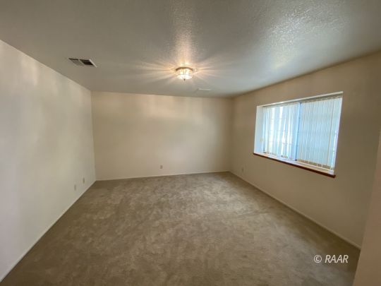 717 North Inyo Street Ridgecrest, CA 93555 - Photo 6 of 26 an empty room with windows and chandelier fan