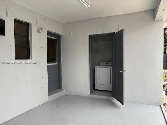 view of an empty room with a cabinet and mirror