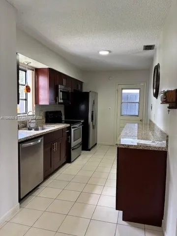 a kitchen with stainless steel appliances granite countertop a sink and a stove