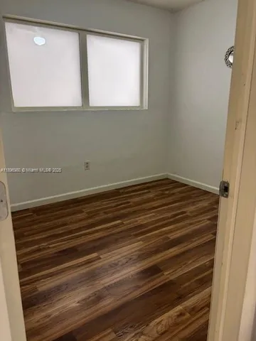 a view of a small space with wooden floor and a window
