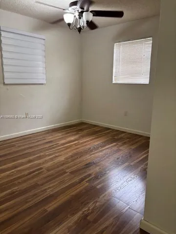 a view of a room with wooden floor and fan
