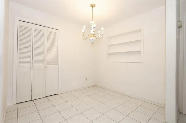 an empty room with chandelier fan