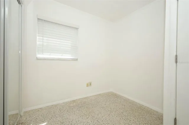 a view of a small space with wooden floor and a window