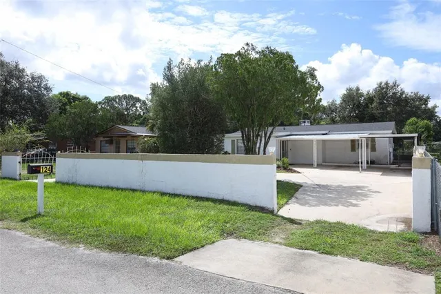 a front view of a house with a garden and trees