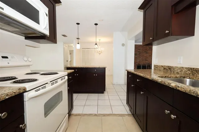 a kitchen with a stove sink and cabinets