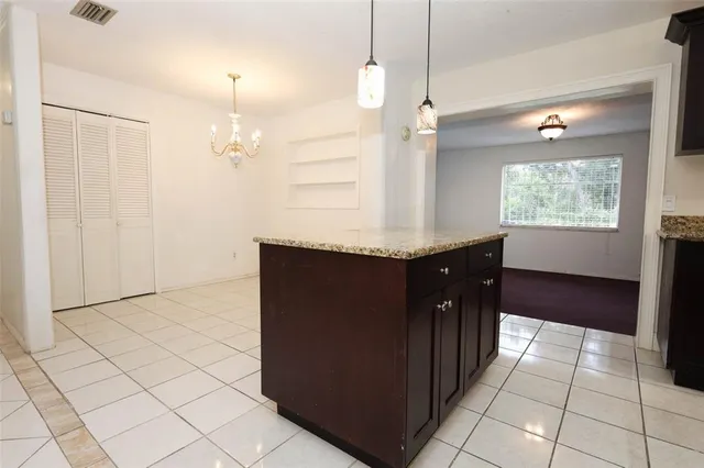 a kitchen with granite countertop a sink a counter space and cabinets