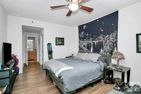 a bedroom with a bed and wooden floor